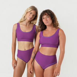 Two women wearing matching purple bikini sets 