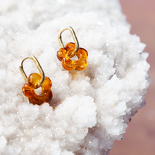 Amber hoop gold waterproof earrings on a white salt surface