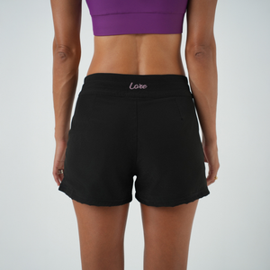 black boardshorts with pink details from the back