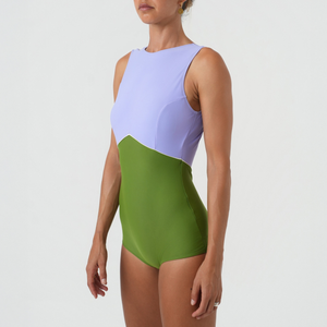 Woman wearing a color-blocked swimsuit with purple and green
