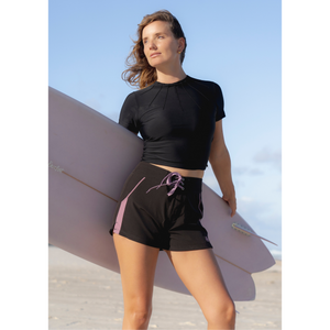 Woman in black top and boardshorts 