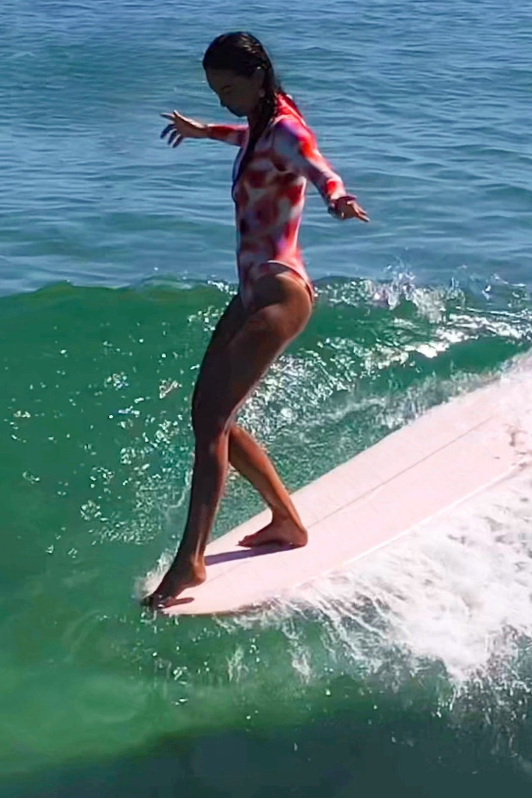 woman surfing on a wave in red lore of the sea surfsuit 