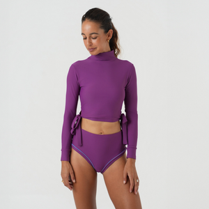 Woman wearing a purple two-piece swimsuit 