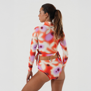 Woman wearing a colorful floral long-sleeve top and bikini bottoms set 