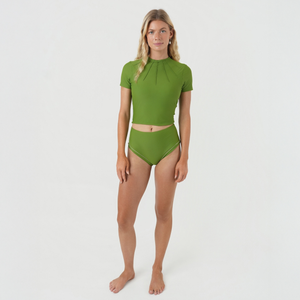 Woman wearing a green bikini bottoms with crop top set 