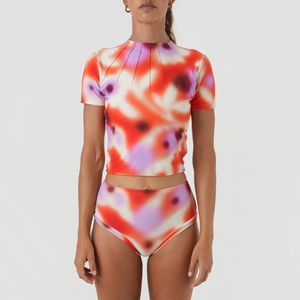 women wearing a colorful rash top short sleeves and high-waist surf bikini bottoms