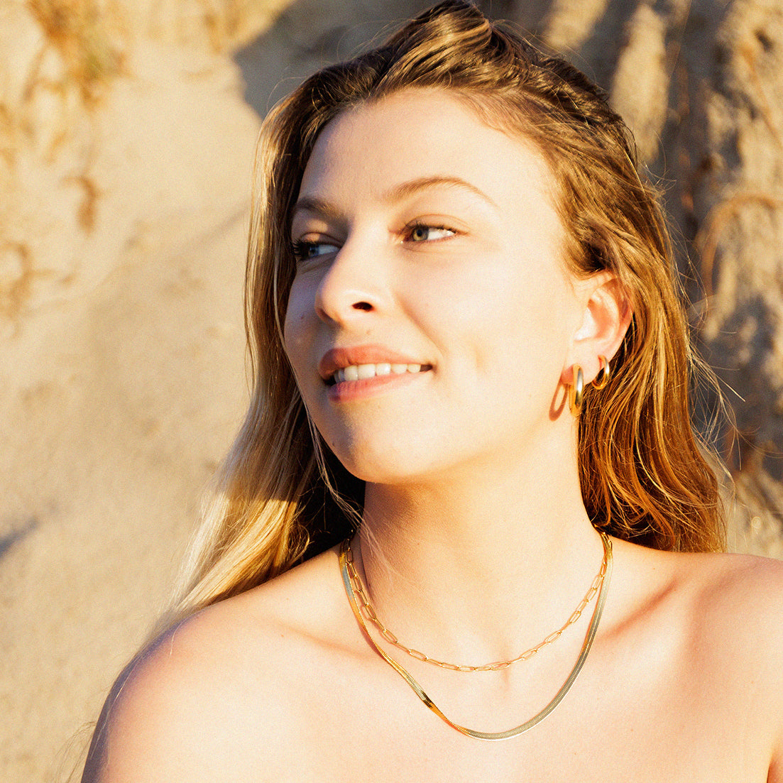 Beach girl wearing waterproof gold jewellery and earrings
